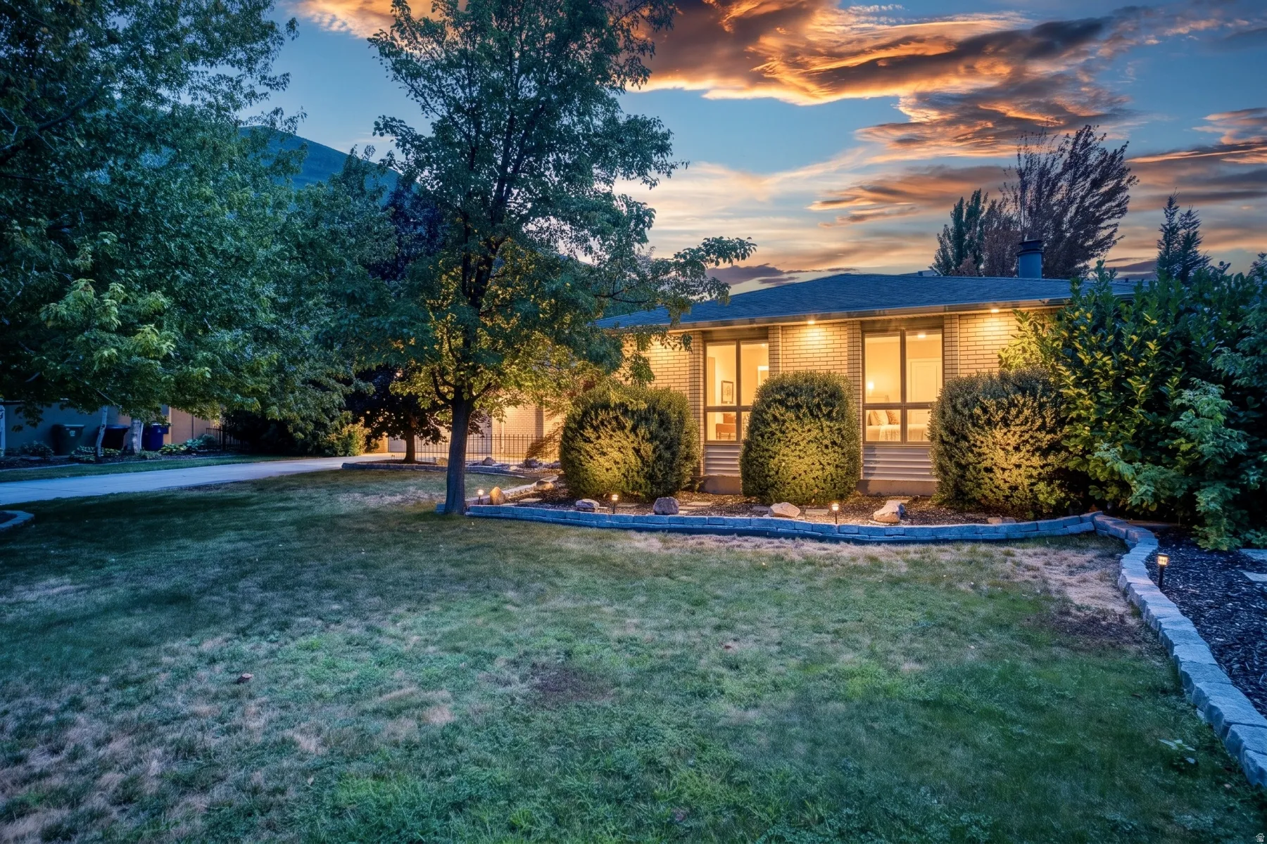 Modern residence with illuminated interior spaces and expansive landscaped grounds
