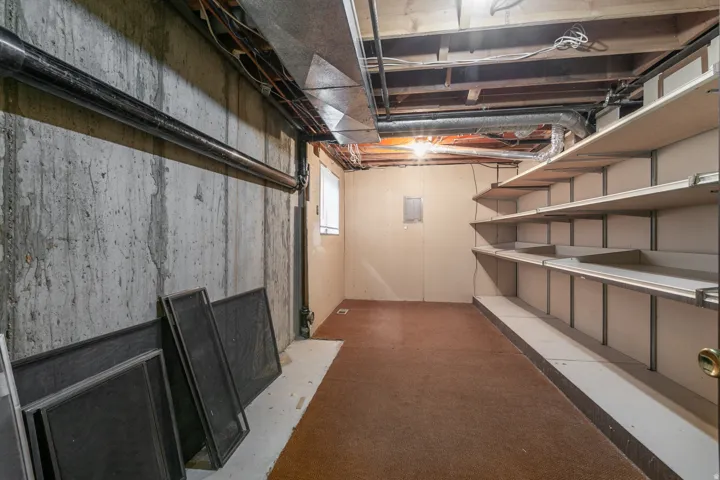 Expansive unfinished basement featuring concrete walls and exposed overhead joists
