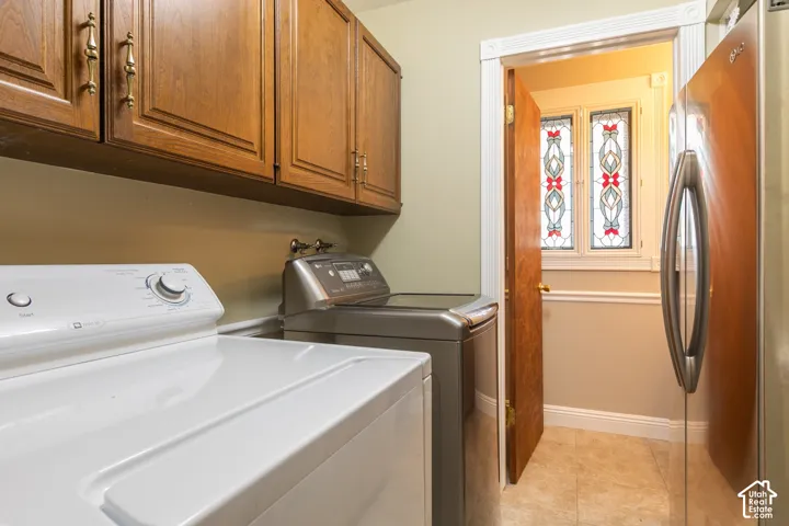 Wood-finish cabinetry with brass hardware, tiled flooring, and decorative stained-glass windows