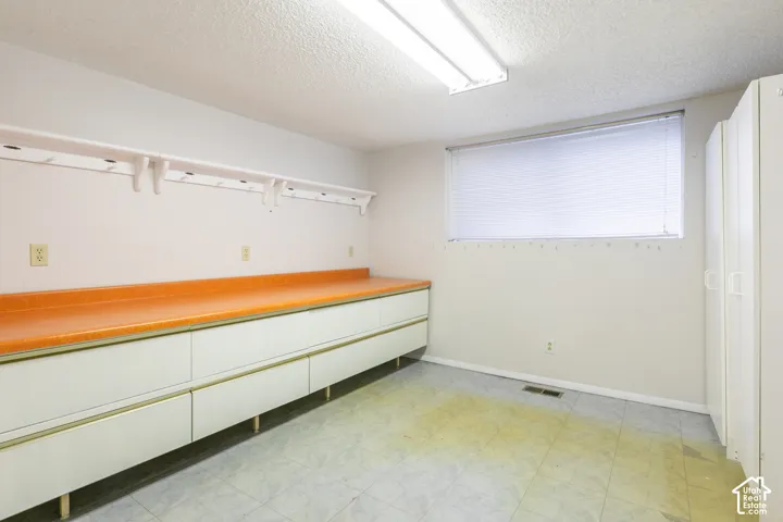 Built-in cabinetry with an orange countertop, overhead shelving, window with blinds, and recessed lighting