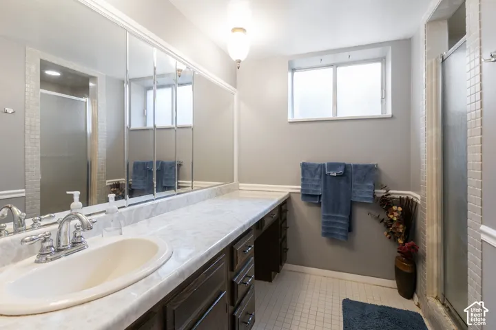 Vanity with integrated sink, chrome faucet, and expansive wall-mounted mirror
