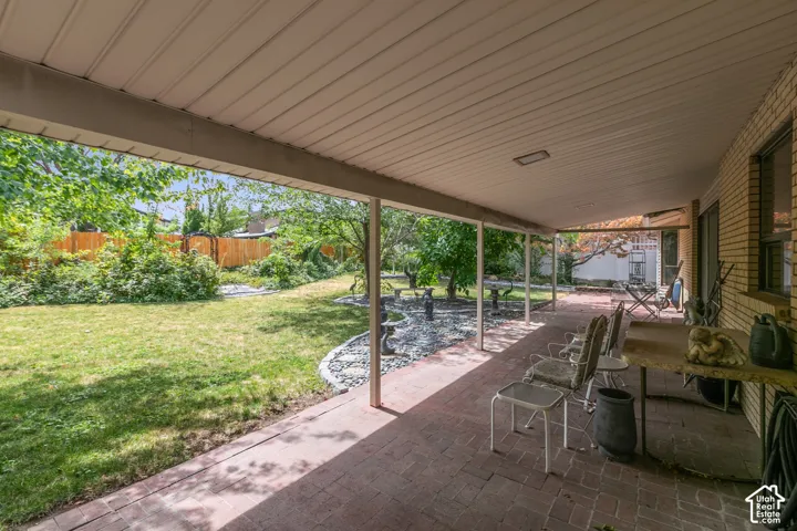 Covered patio featuring a brick surface, white ceiling, and a supporting column