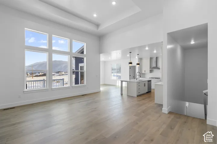 Expansive living area with wood-finish flooring and a high tray ceiling