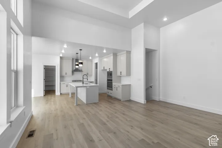 Open-concept living area featuring wood-finish flooring, recessed lighting, and a kitchen island with seating