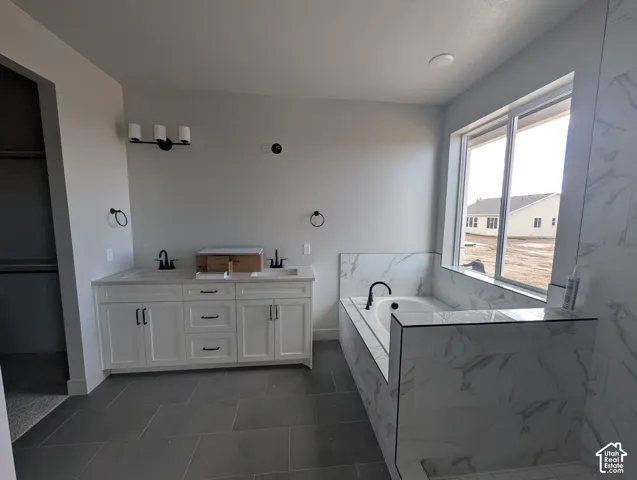 Double vanity featuring white cabinetry, dual undermount sinks, and matte black fixtures