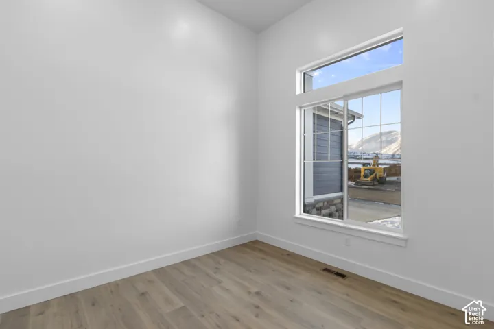 High ceilings with a transom window, large window with grid pattern, and wood-finish flooring