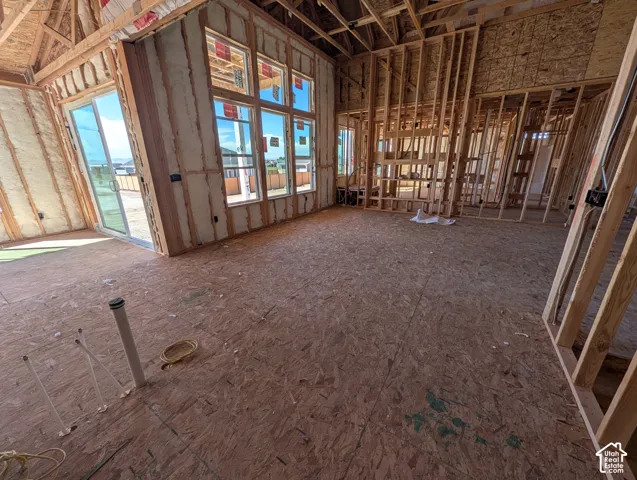 Framed interior construction featuring wall insulation, multiple windows, and a sliding glass door