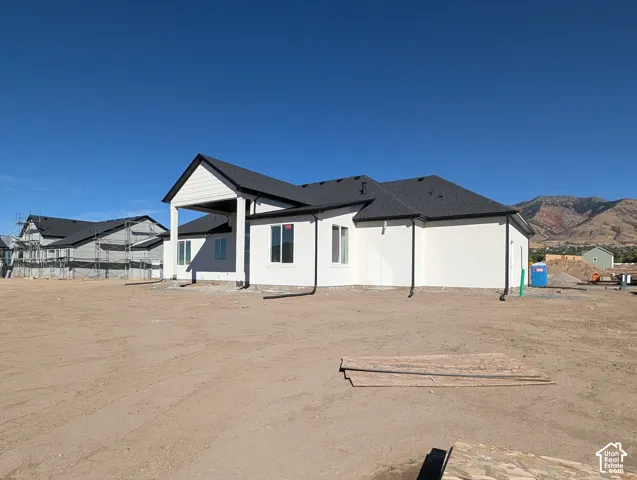 Newly constructed residence with a white exterior, dark shingle roof, and a covered entry