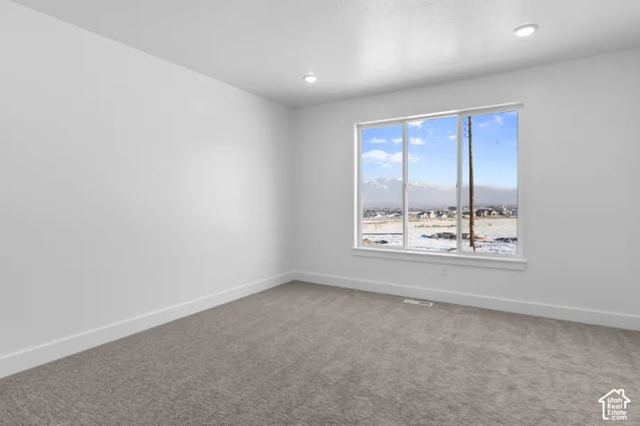 Recessed ceiling lighting, neutral carpeting, white trim, and a multi-pane window with mountain scenery