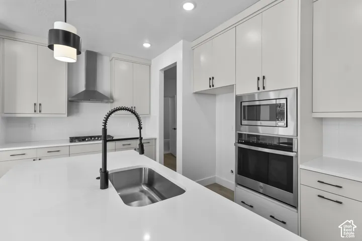 Stainless steel built-in microwave and oven, sleek black range, and contemporary cabinetry with black hardware