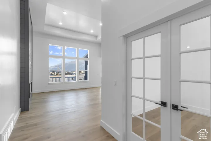 Wood-finish flooring, recessed lighting, and a tray ceiling