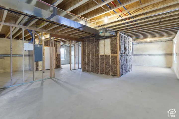 Unfinished lower level featuring exposed framing, concrete flooring, and visible ductwork