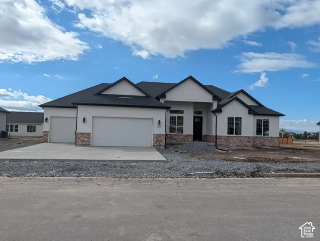 Single-story residence featuring a multi-gabled roofline, horizontal siding, stone veneer accents, and a three-car garage