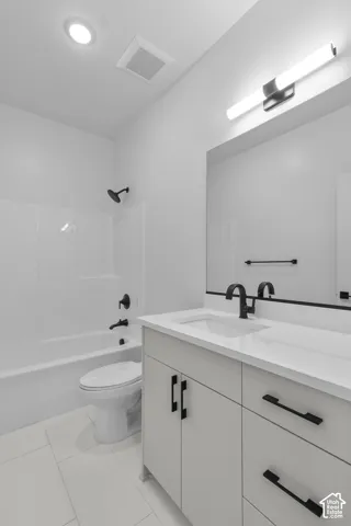White tile flooring, white vanity with integrated sink, matte black hardware, white tub-shower combination, and recessed lighting