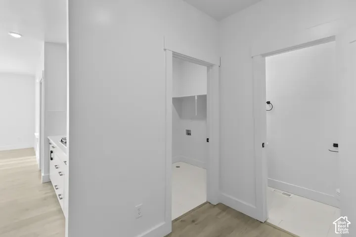 Laundry space with white shelving and tile flooring