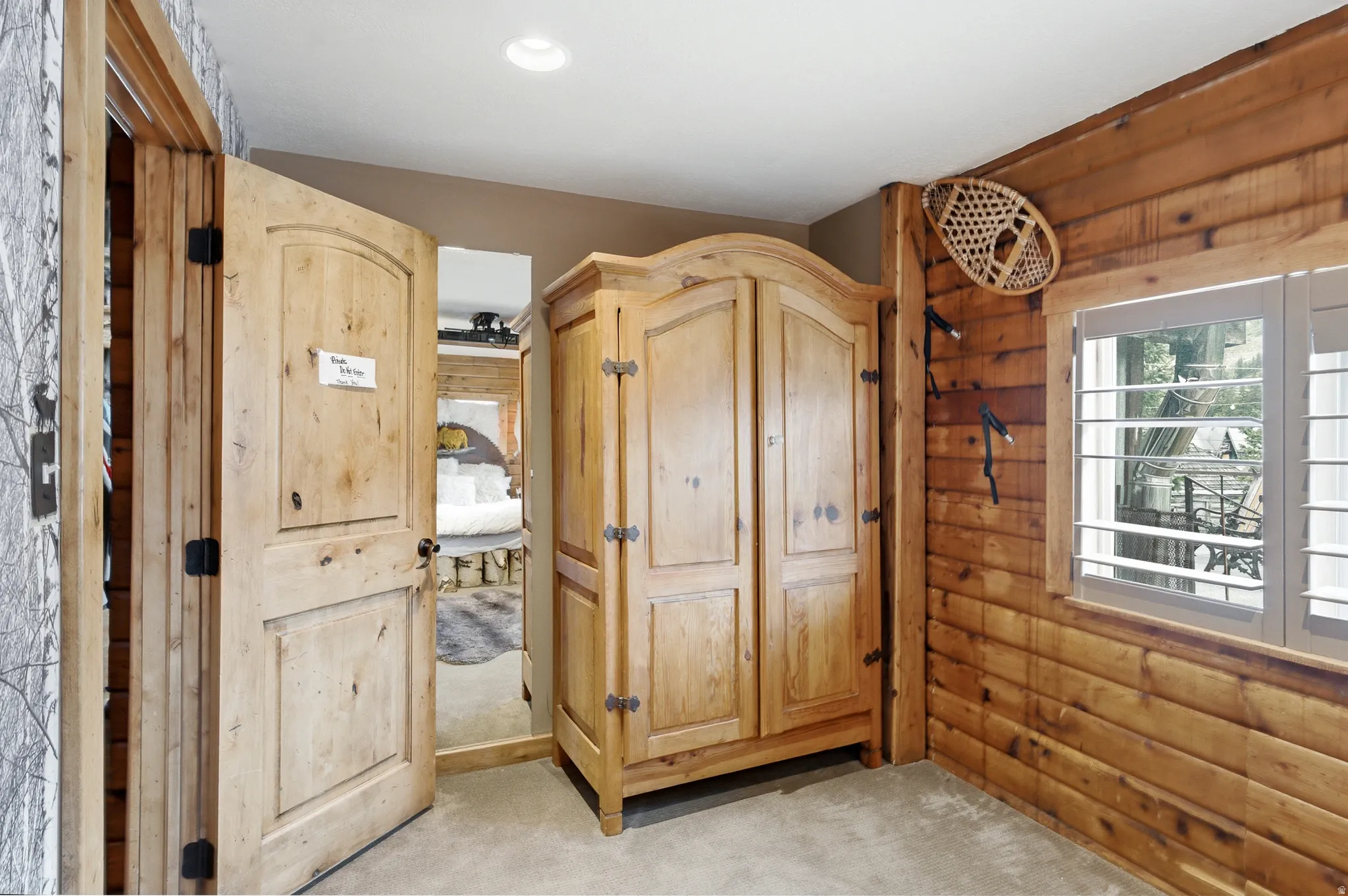Wood-paneled wall, plantation shutters, and recessed ceiling lighting