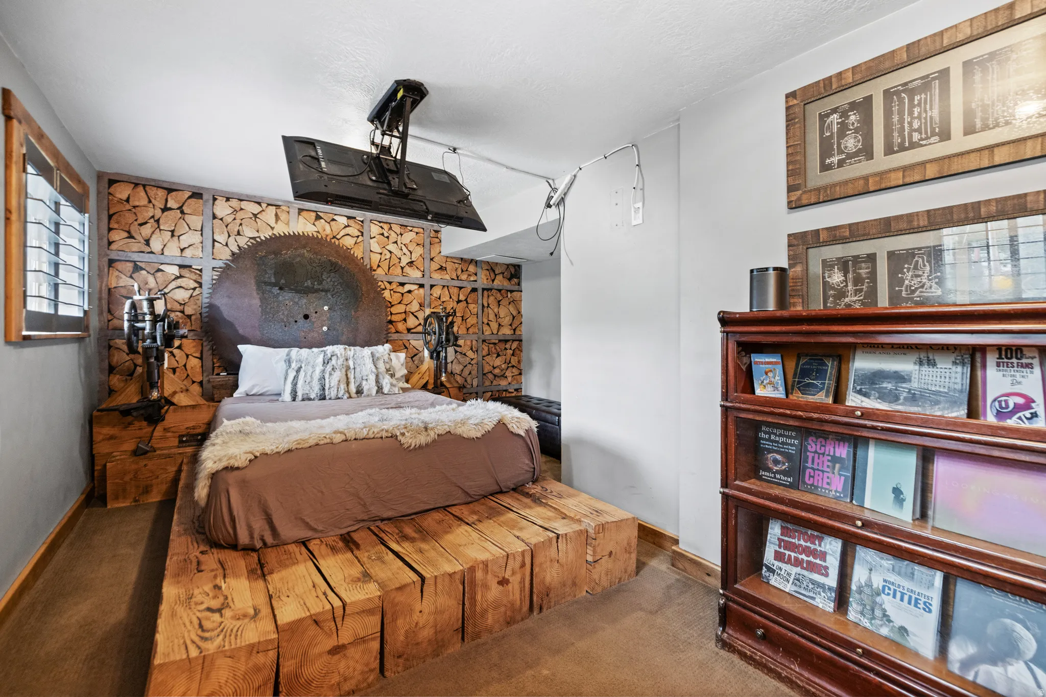 Custom wood block bed frame, unique wood-panel accent wall, integrated wall-mounted television, and wood-framed window with shutters