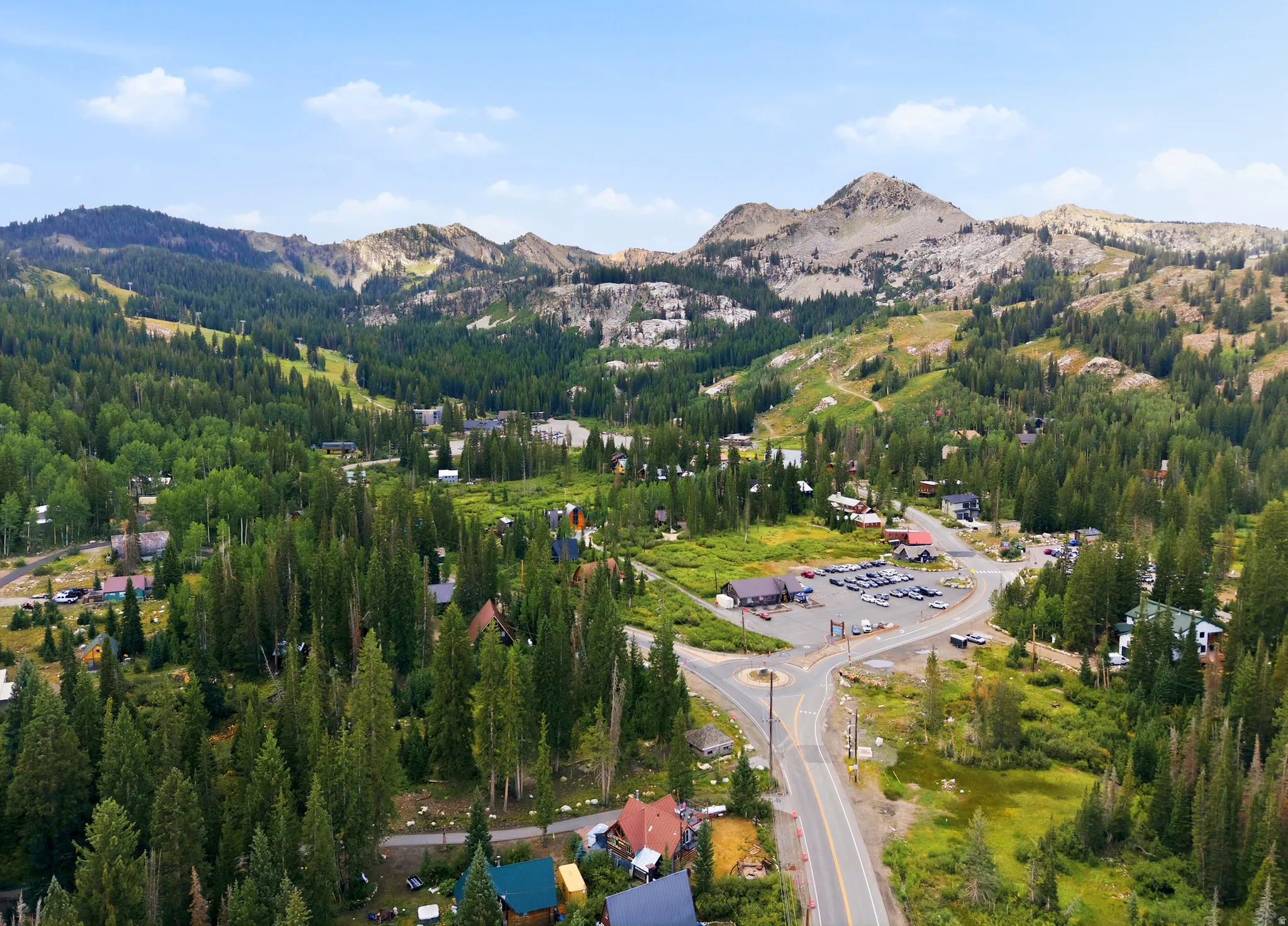 Mountainous terrain with extensive tree coverage and visible roadway infrastructure
