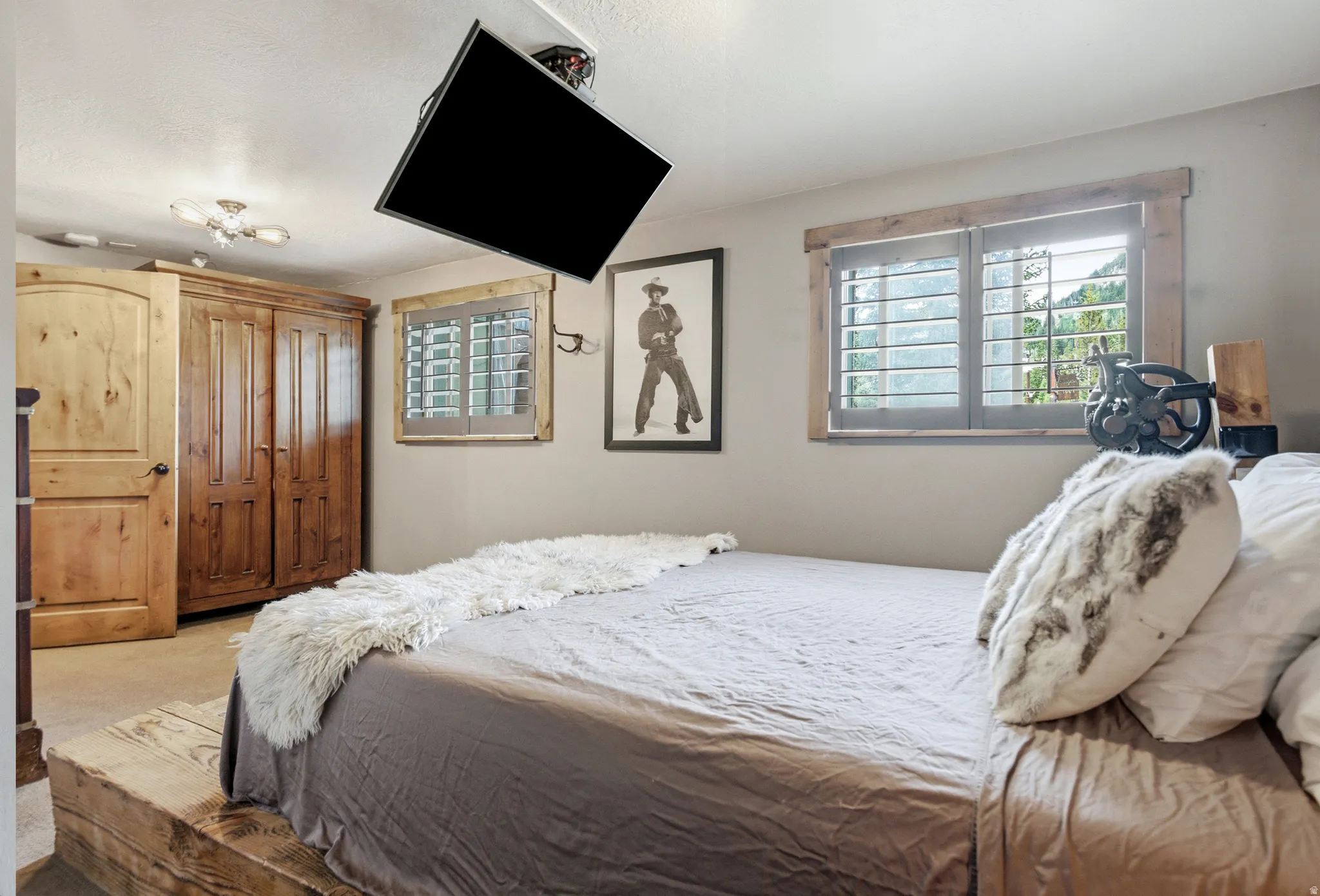 Wood-finish plank flooring, wood-framed windows with plantation shutters, ceiling-mounted light fixture, and wood-paneled door