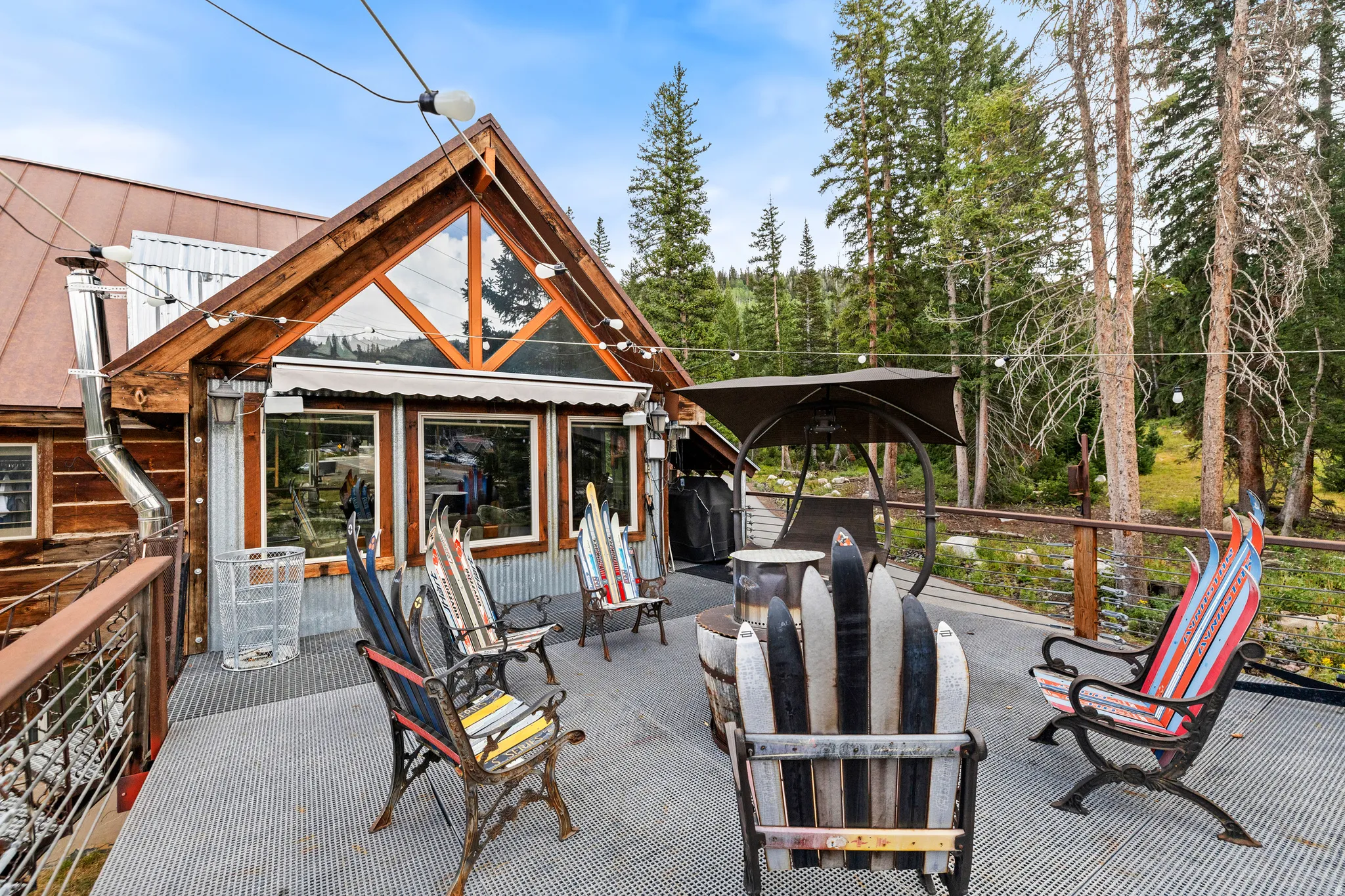 Expansive outdoor deck with a metal railing and string lighting