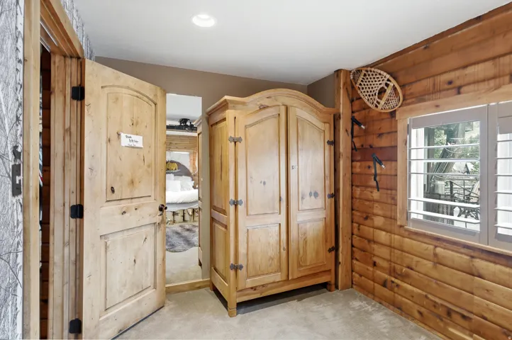 Wood-paneled wall, plantation shutters, and recessed ceiling lighting