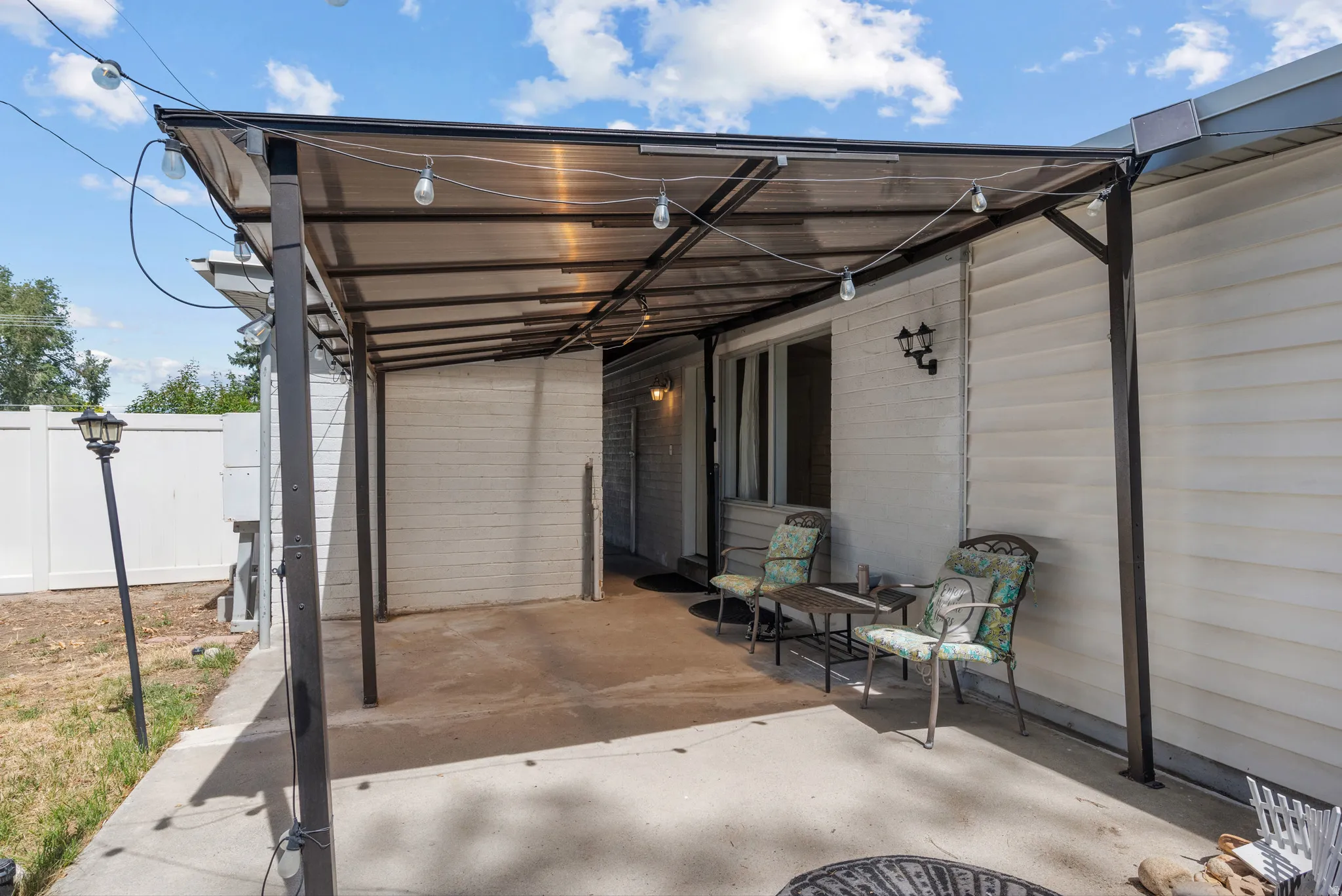 Covered patio featuring a translucent roof panel, concrete flooring, and exterior wall siding