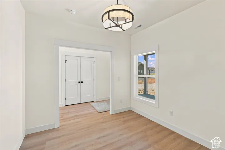Wood-finish flooring with white trim and walls
