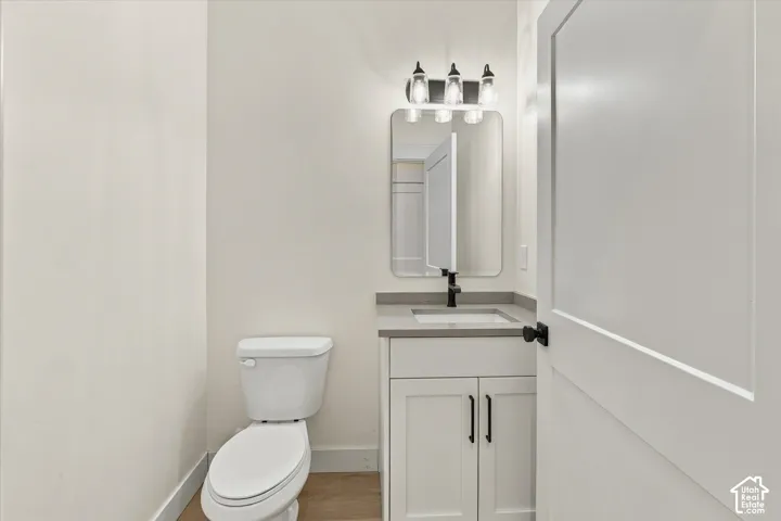 White vanity with shaker-style cabinetry, matte black hardware, and a gray countertop