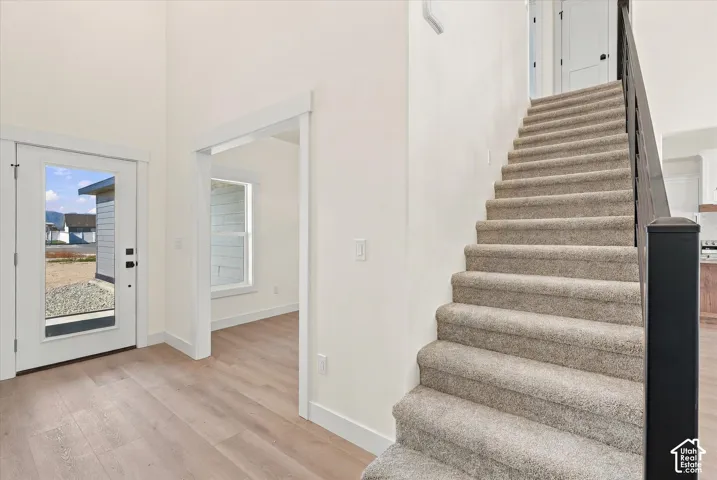 Entryway with high ceilings, wood-finish flooring, and a full-light entry door