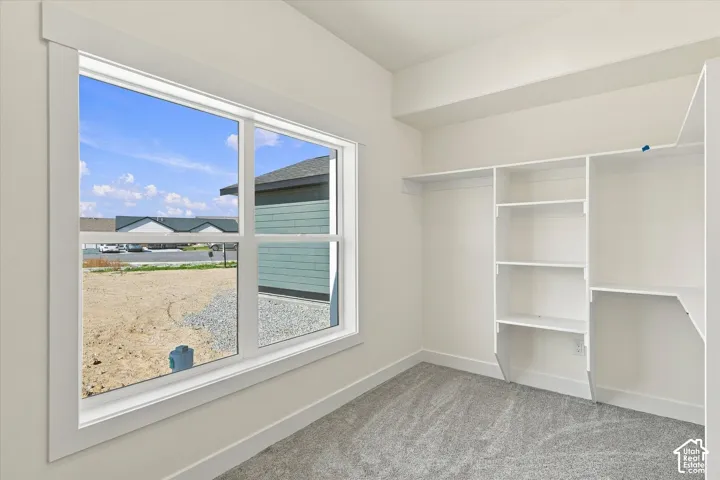 Carpeted interior with a large window and white trim