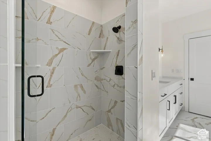 Glass-enclosed shower with large format tile walls and a matte black showerhead