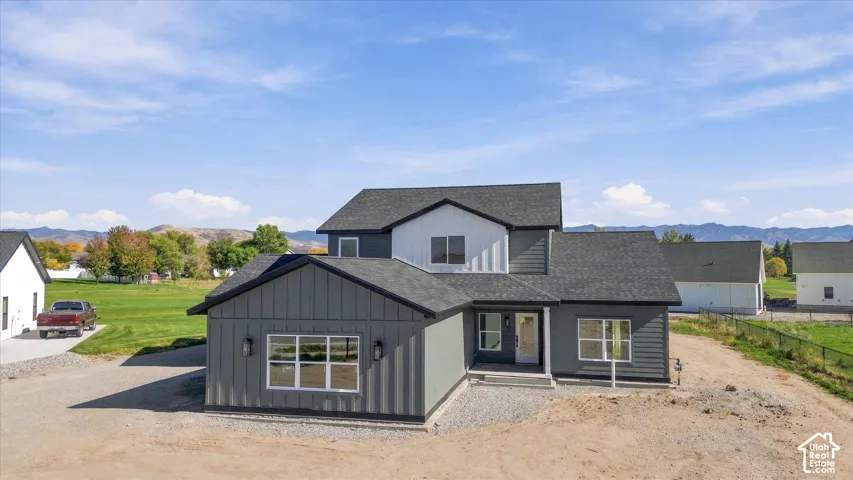 Contemporary exterior with multi-toned siding, dark roof, and multiple windows