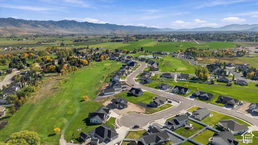 Residential community featuring cul-de-sac streets, manicured green spaces, and mountain backdrops
