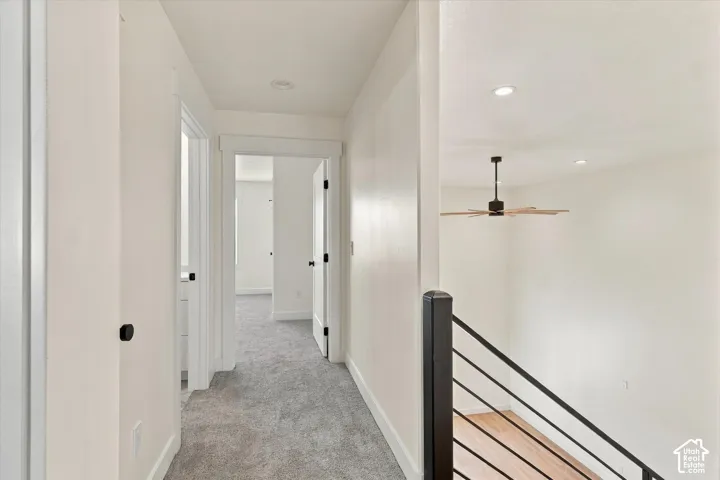 Hallway featuring gray carpet flooring, white walls, recessed lighting, and white trim
