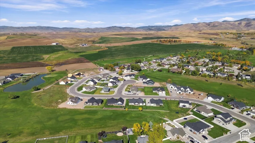 Expansive community with varied architectural styles, surrounded by open fields and distant mountains