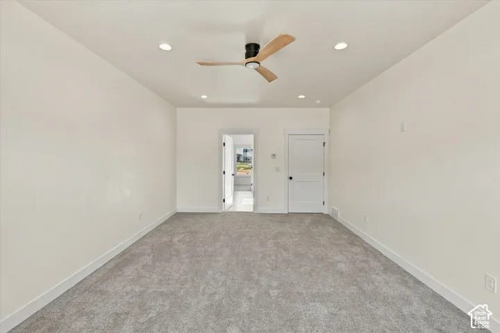 Recessed lighting, ceiling fan with wood-finish blades, light gray carpeting, and white interior doors