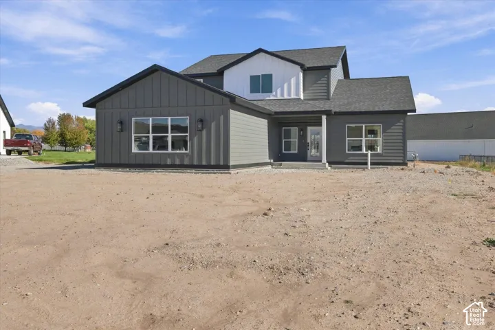 Two-story exterior with dark gray siding and white vertical accents