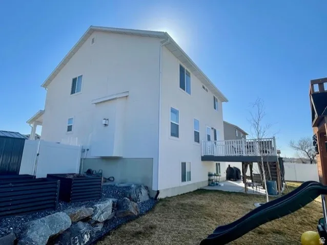Back/side yard; Multi-story exterior with a raised deck featuring white railings