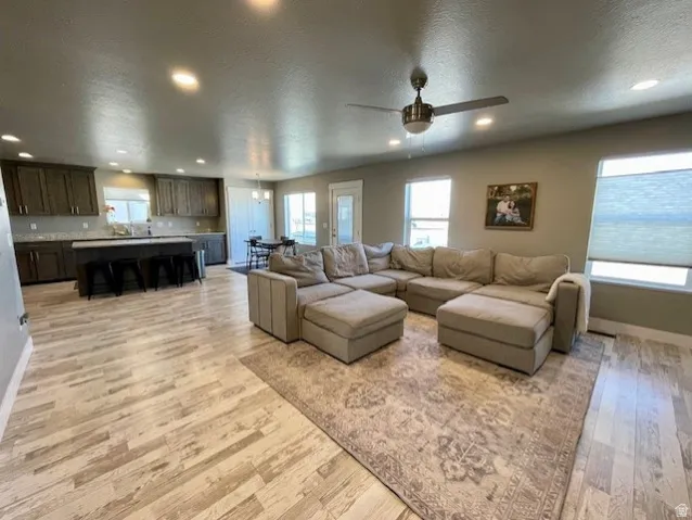 Open-concept living area with wood-finish flooring, recessed lighting, and a ceiling fan.  Great for entertaining!