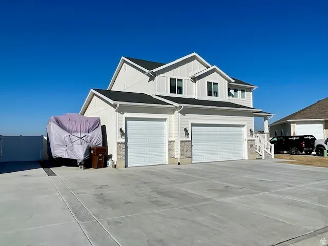 Two-story residence featuring white siding and dark shingle roofing