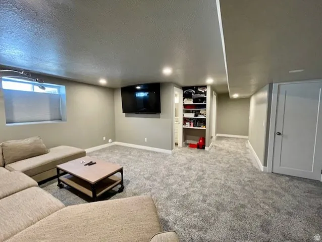 Downstairs family room; Recessed lighting illuminates the carpeted floor