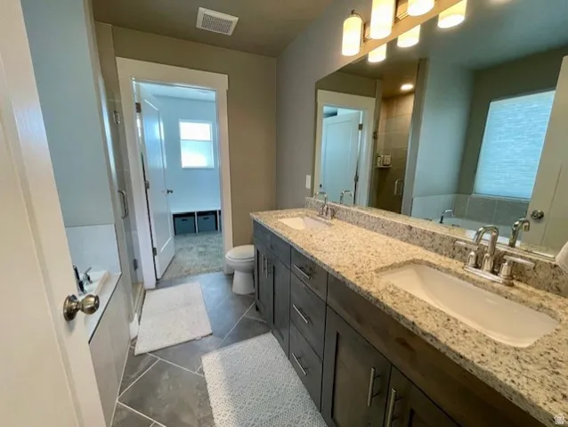Primary bathroom; Dual vanity with integrated sinks, granite countertops, and wood-finish cabinetry