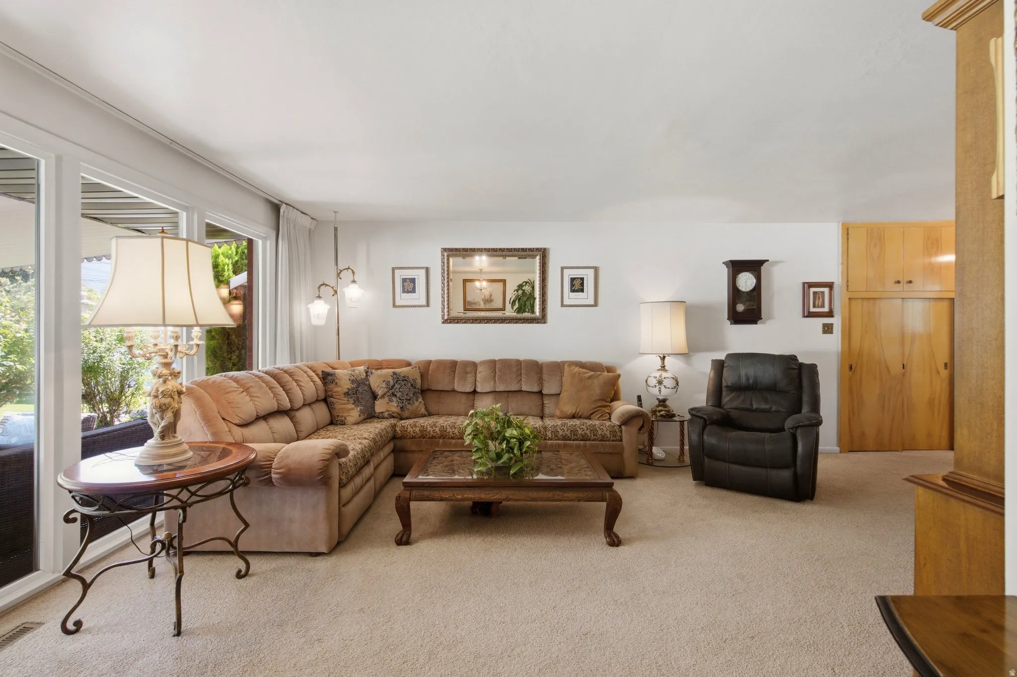 Sliding glass doors, wood-finish built-in cabinetry, wall-mounted decor, and carpeted flooring
