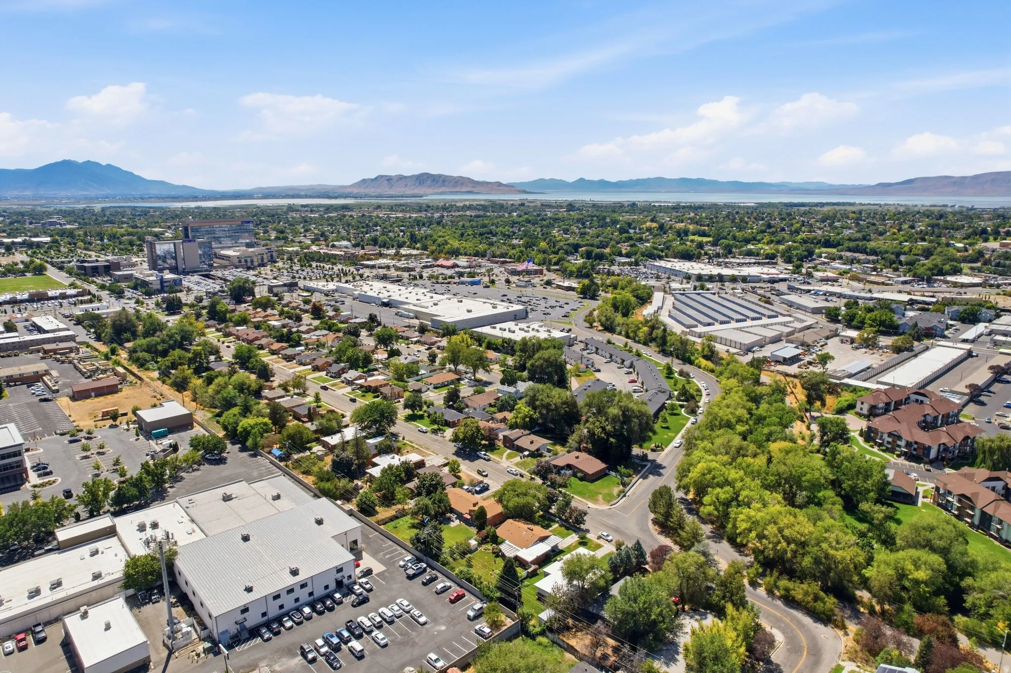 Expansive neighborhood setting with established tree canopy, diverse residential structures, and various commercial buildings