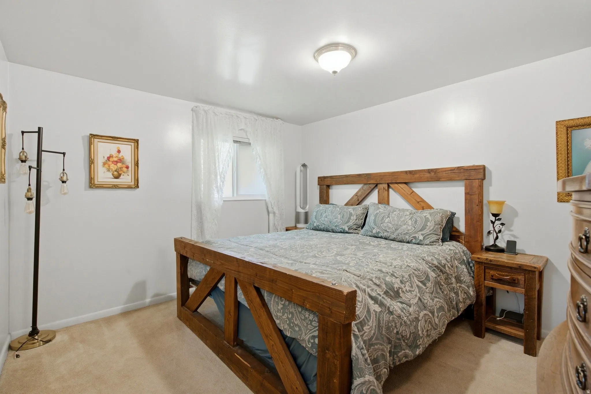 Carpeted flooring, white walls, built-in ceiling light fixture, and window with sheer curtains