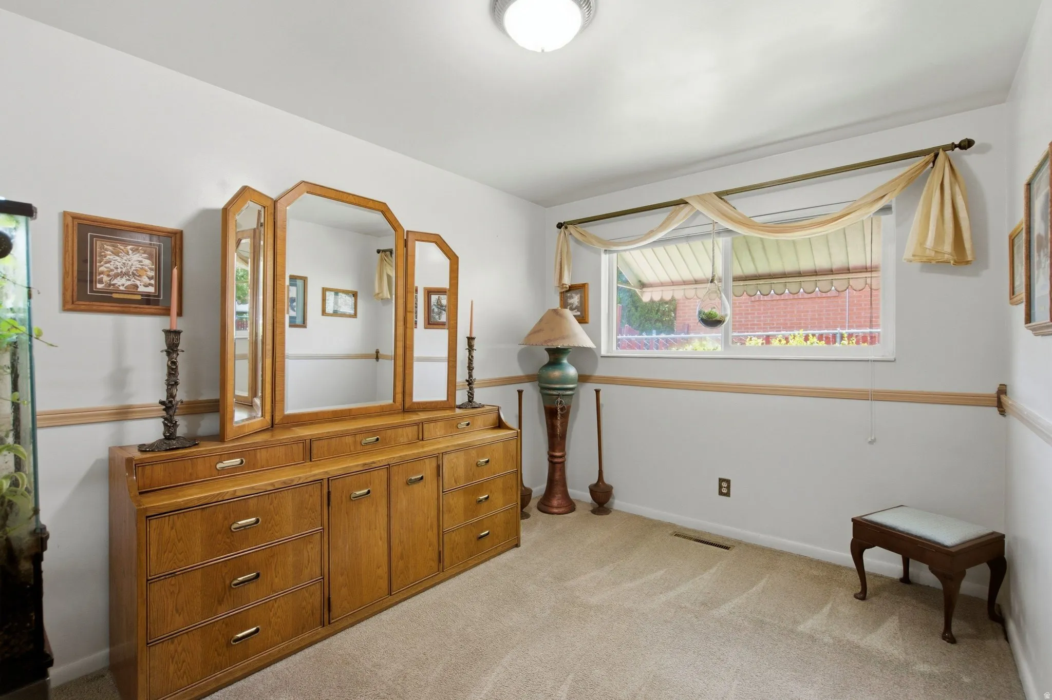 Recessed lighting, wood-finish trim, carpeting, and a window with a valance