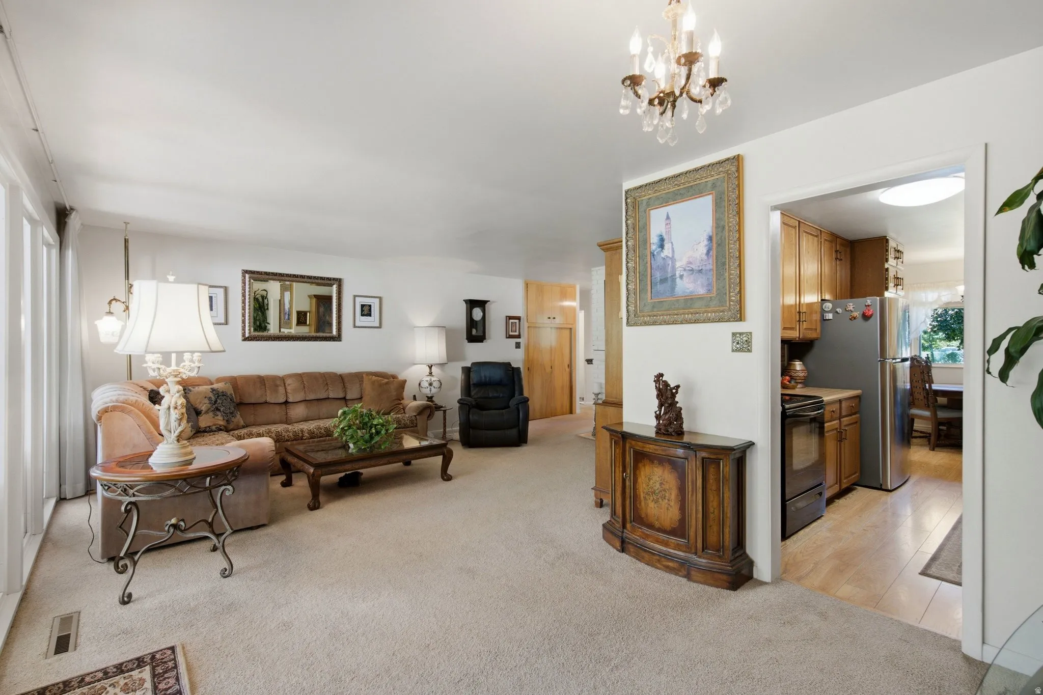 Carpeted living area with a decorative chandelier