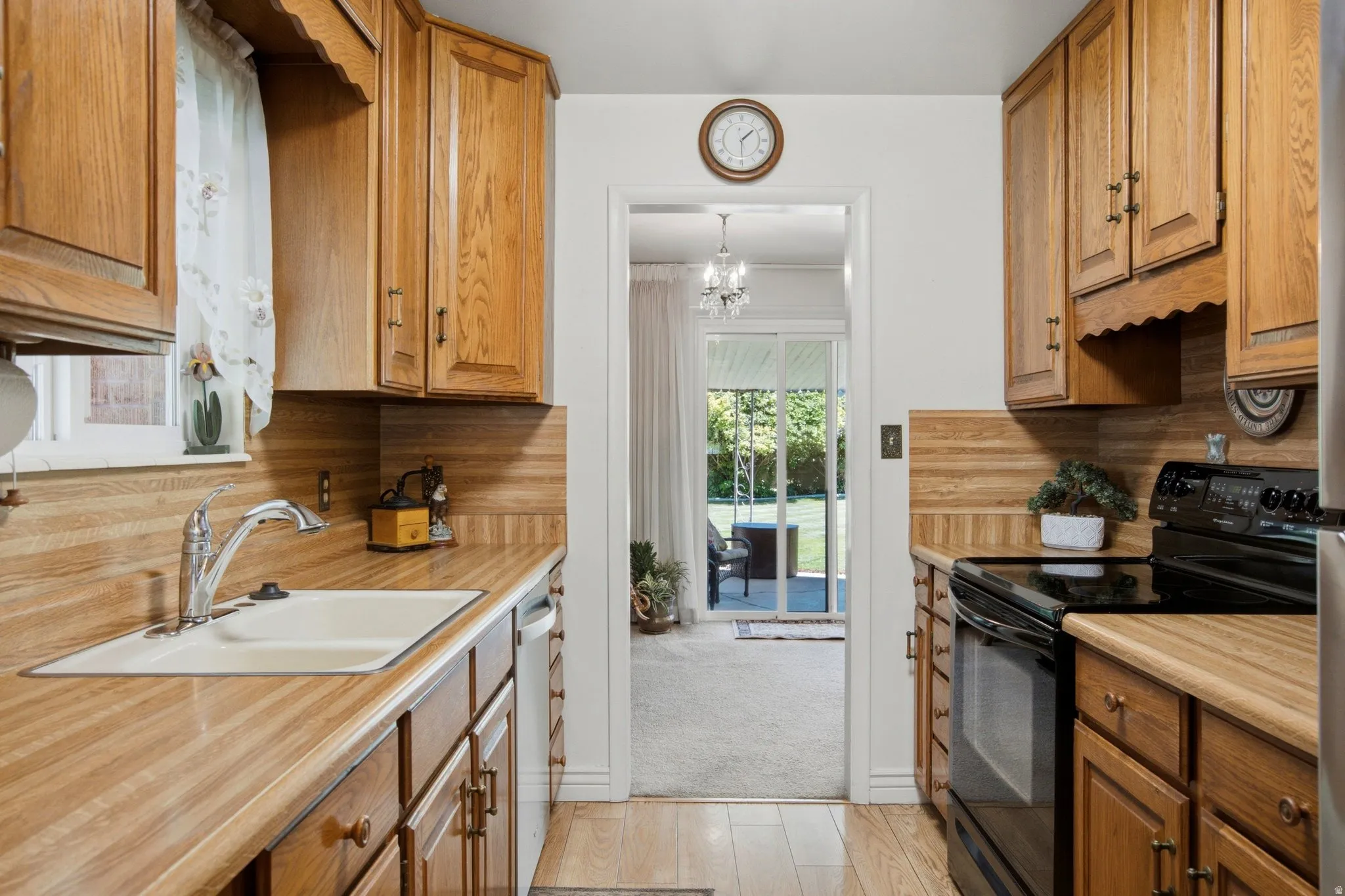 Kitchen featuring wood cabinetry, wood-finish countertops, and a stainless steel sink with a chrome faucet
