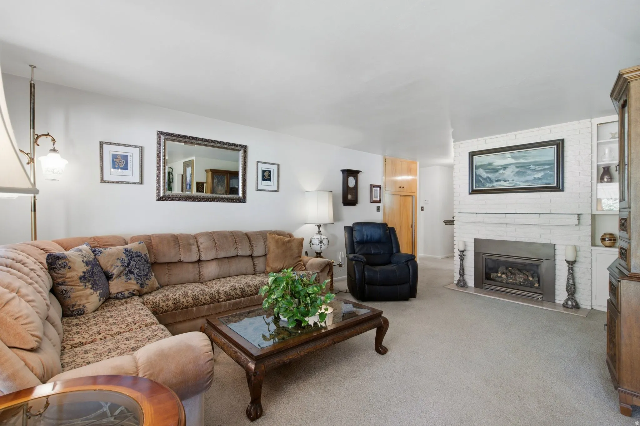 White brick fireplace with a mantle, built-in shelving, and a gas insert