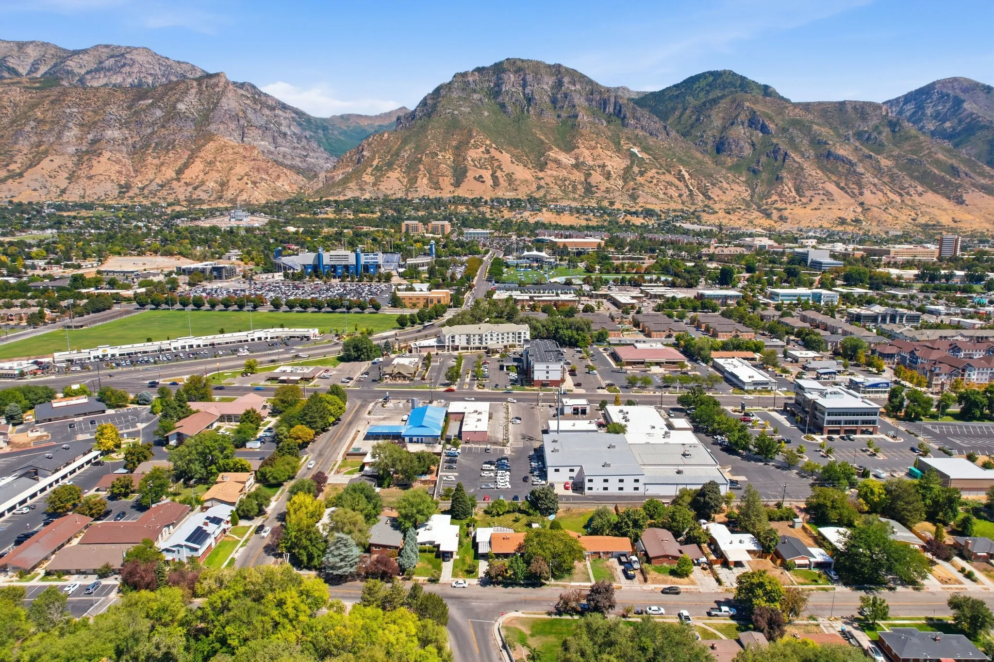 Expansive mountain backdrop, established residential areas, commercial properties, and developed infrastructure